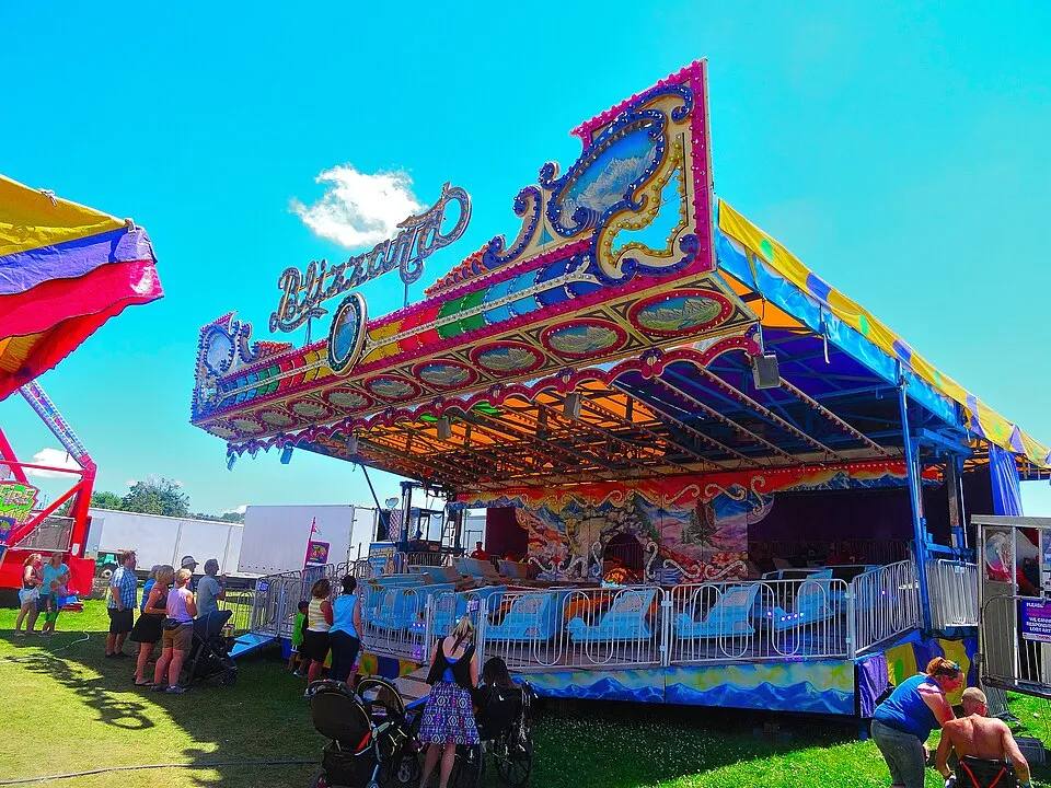 Silver Streak spinning carnival ride with painted canopy at a fair — fair ride rental Los Angeles