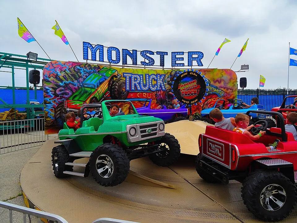 Kids driving mini monster trucks on the Super Trucks kiddie ride — kids carnival ride rental Los Angeles