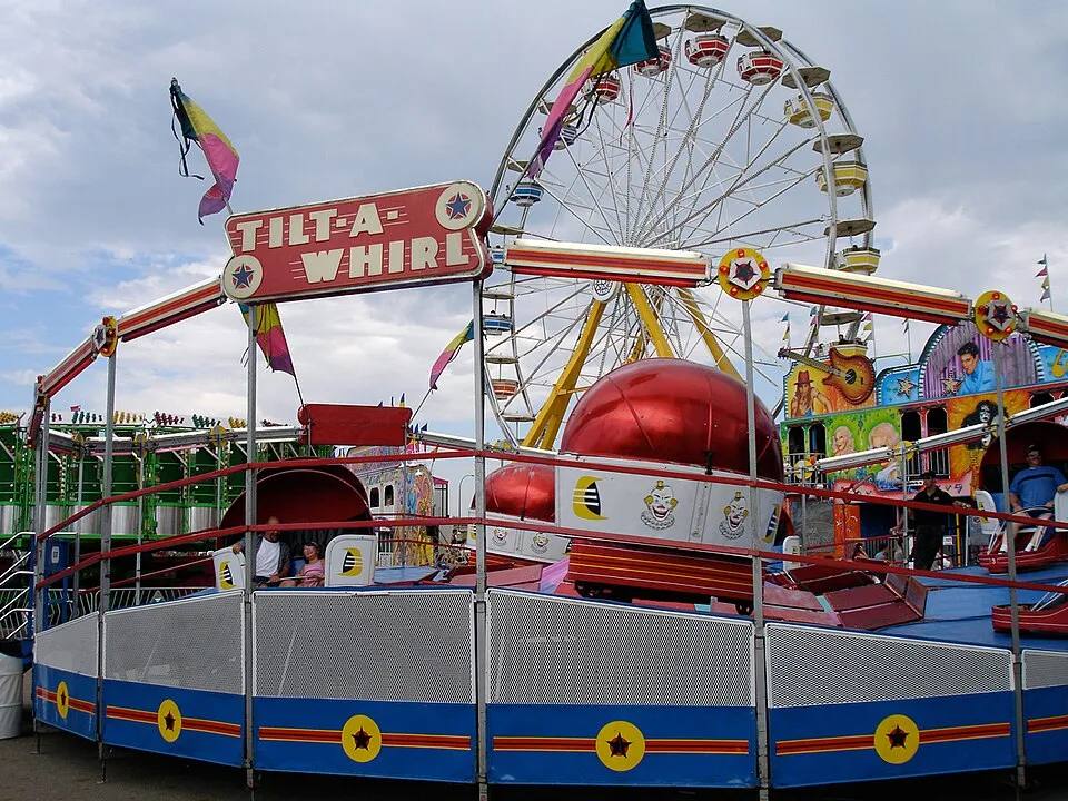 Tilt-A-Whirl carnival ride rental Los Angeles with Ferris wheel behind